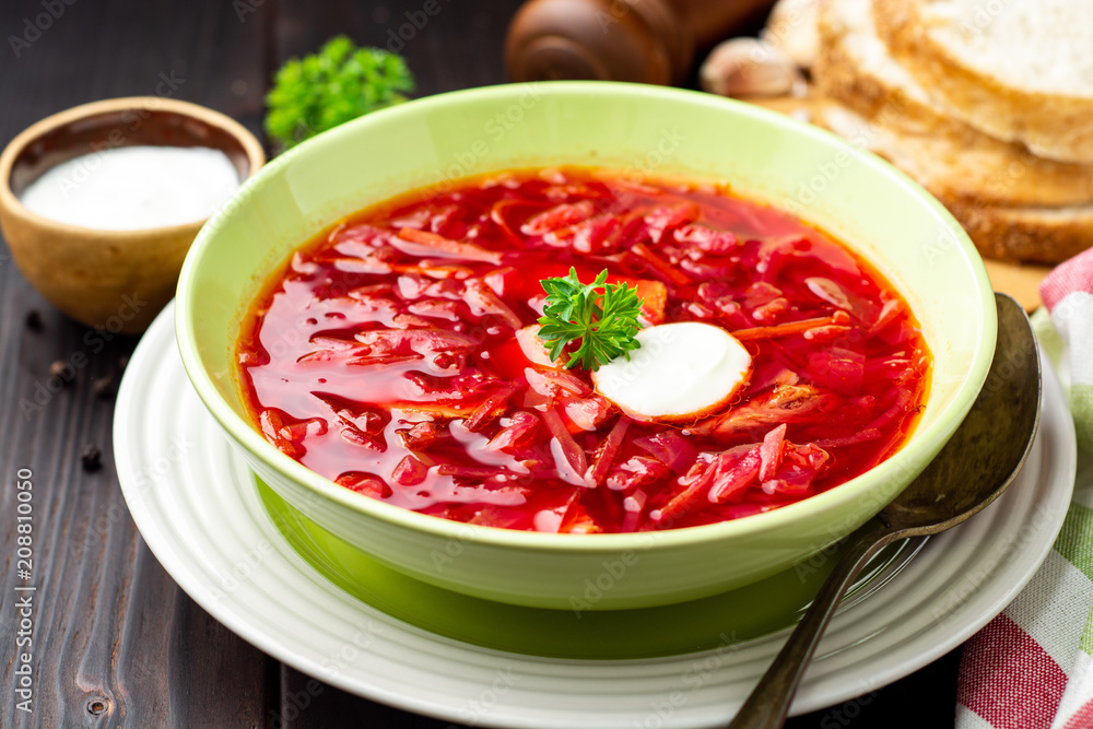 Borsch - traditional Ukrainian and Russian beetroot soup on dark wooden background