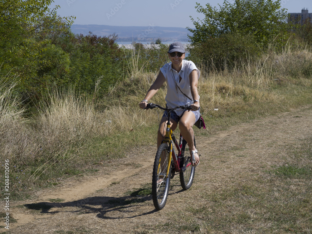 Woman cycling in field, Kladovo, Bor District, Serbia