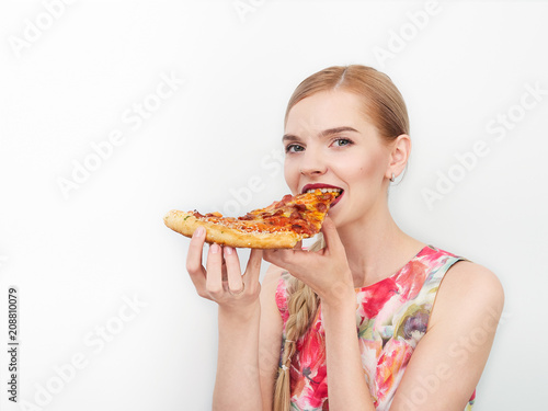 Beauty portrait of young beautiful cheerful young fresh looking woman with bright trendy make up long blond healthy hair enjoying pizza.
