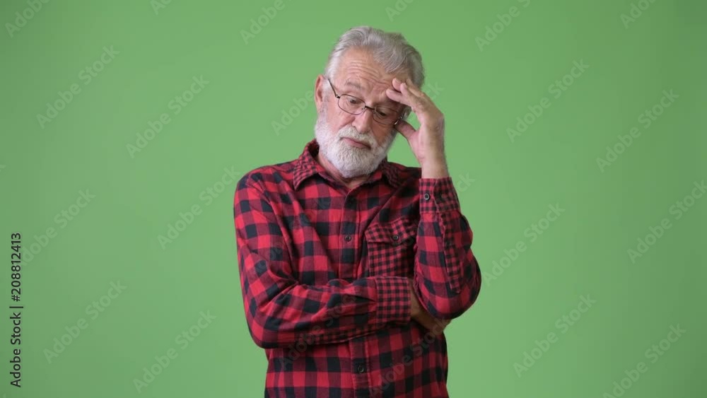 Handsome senior bearded man against green background Handsome senior bearded man against green background