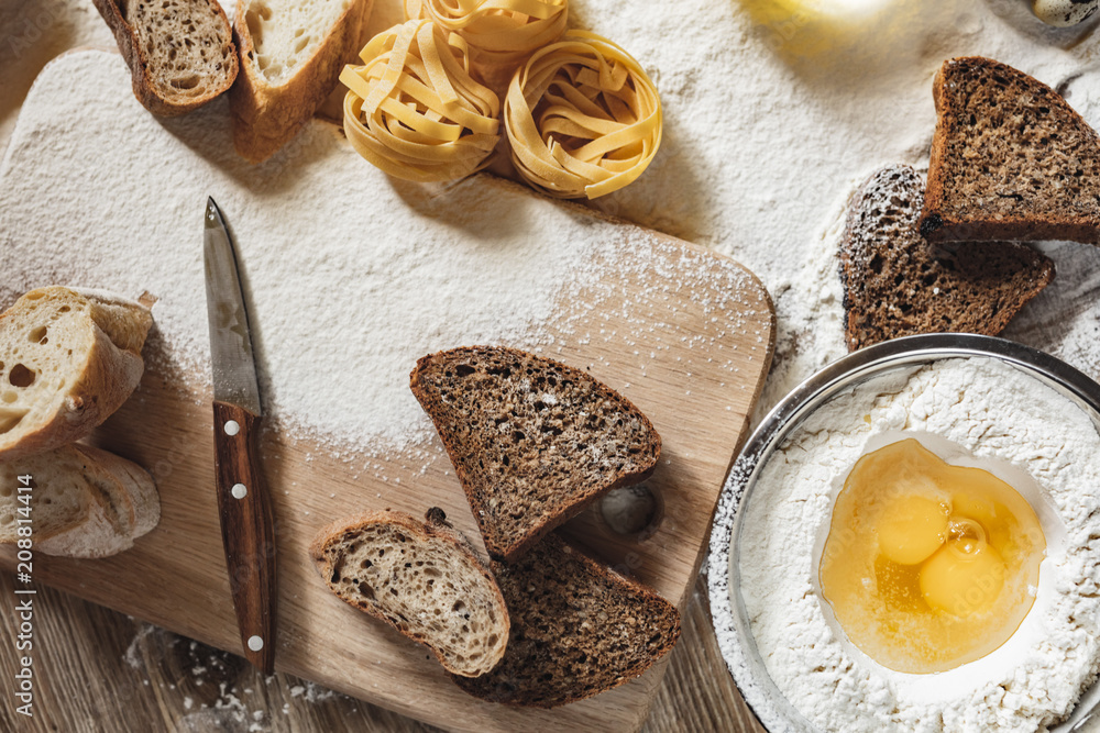 Sliced homemade wheat bread with wheat flour on a wooden background. Ton view Sliced homemade wheat bread with wheat flour on a wooden background. Ton view