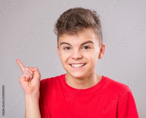Emotional portrait of excited teen boy. Funny cute surprised child 14 year  old looking at camera. Happy teenager pointing fingers up, on gray  background. Stock Photo | Adobe Stock