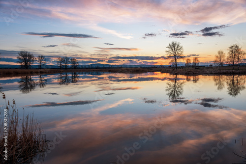 Sunset over calm lake , sky reflection in water. © ba11istic
