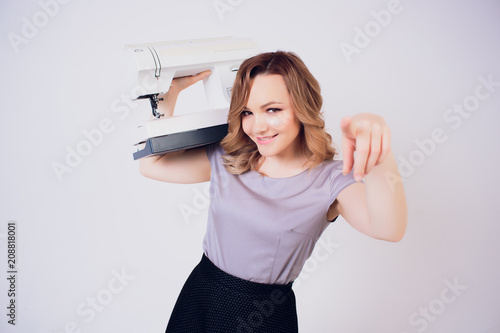 happy Caucasian seamstress holding hanger exellent work. hardworking dressmaker. fools around photo