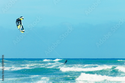 A Kite Surfer riding waves during the annual Otaki Kite Festival held on the Kapiti Coast of New Zealand with copy space.