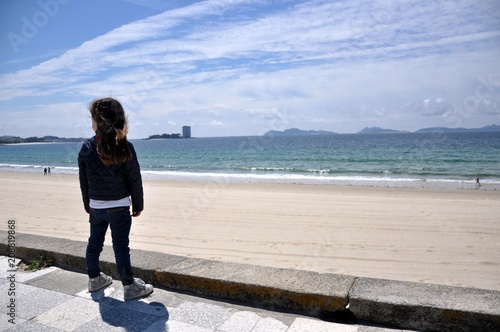 Niña con vistas al océano desde el paseo de Samil en Vigo photo