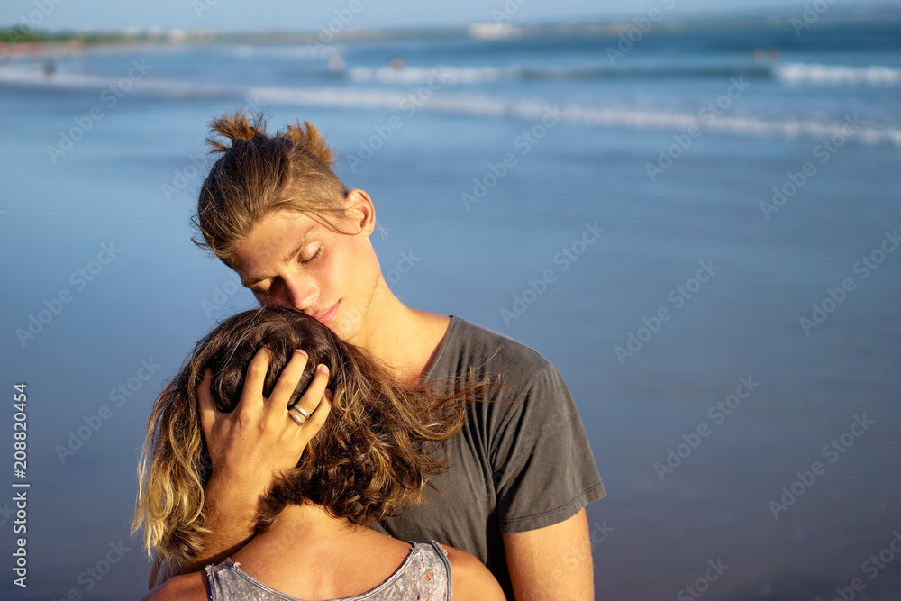 Love and romance. Honeymoon on the sea shore. Beautiful loving couple embracing on the beach. Love and romance. Honeymoon on the sea shore. Beautiful loving couple embracing on the beach.
