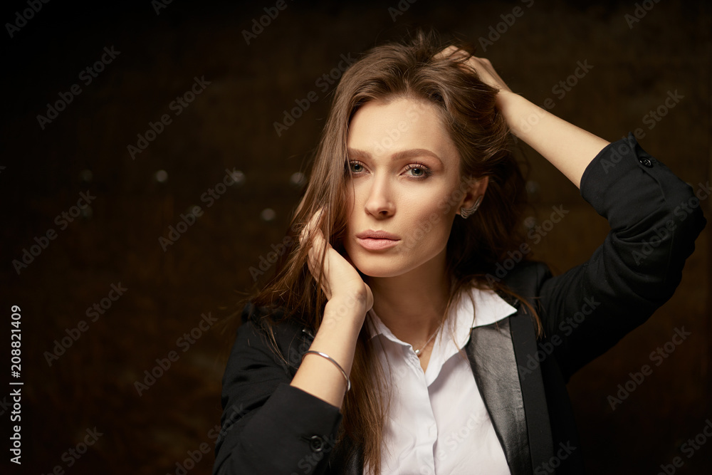 Close up studio Portrait of Beautiful young caucasian woman with long hair against dark background