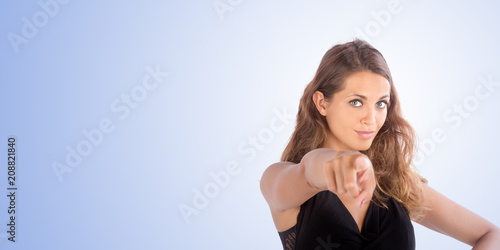 Pretty girl pointing with her hand up. Copy space photo with customizable background.