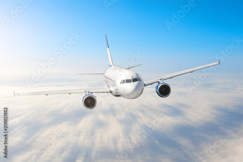 Airplane in the sky above the clouds flight journey sun height speed motion blur. Passenger commercial aircraft. Business travel. Aerial.