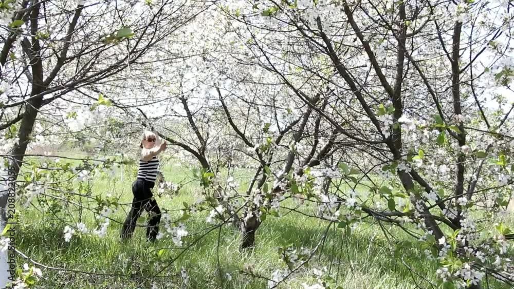 girl in sunglasses runs through the blooming garden and enjoying life girl in sunglasses runs through the blooming garden and enjoying life