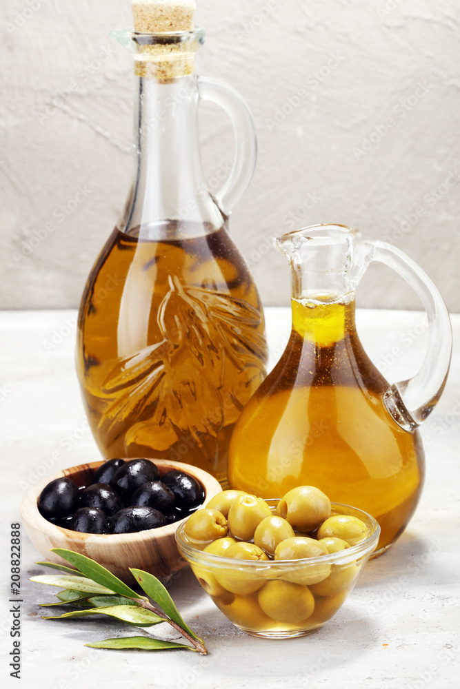 Bottle virgin olive oil and oil in a bowl with some olives Bottle virgin olive oil and oil in a bowl with some olives