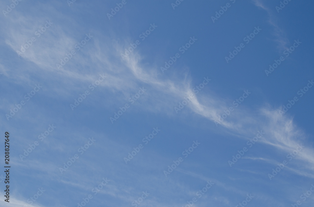 Natural background: blue sky with pale transparent clouds