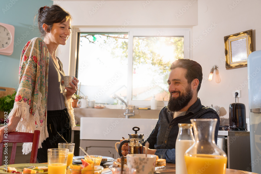 Cheerful couple having breakfast in the kitchen of their house Cheerful couple having breakfast in the kitchen of their house