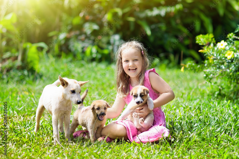 Kids play with puppy. Children and dog in garden. Kids play with puppy. Children and dog in garden.