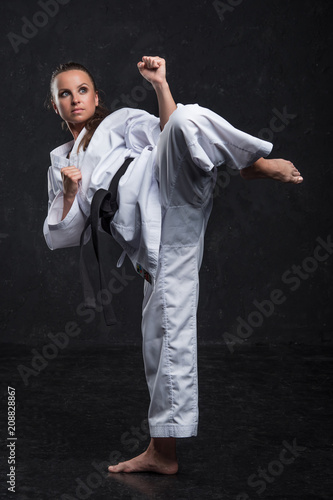  A girl in a white kimono with a black belt on a dark background