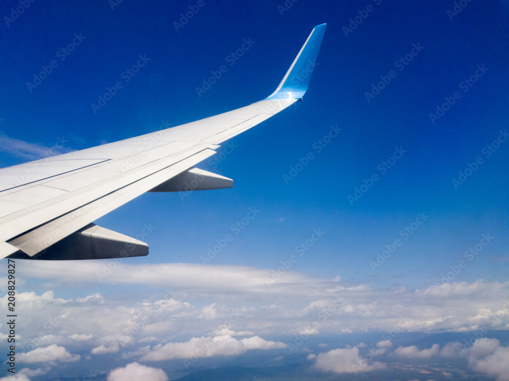 Wing of an airplane flying above the clouds Wing of an airplane flying above the clouds