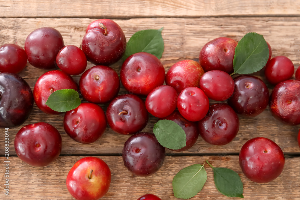 Ripe juicy plums on wooden table Ripe juicy plums on wooden table