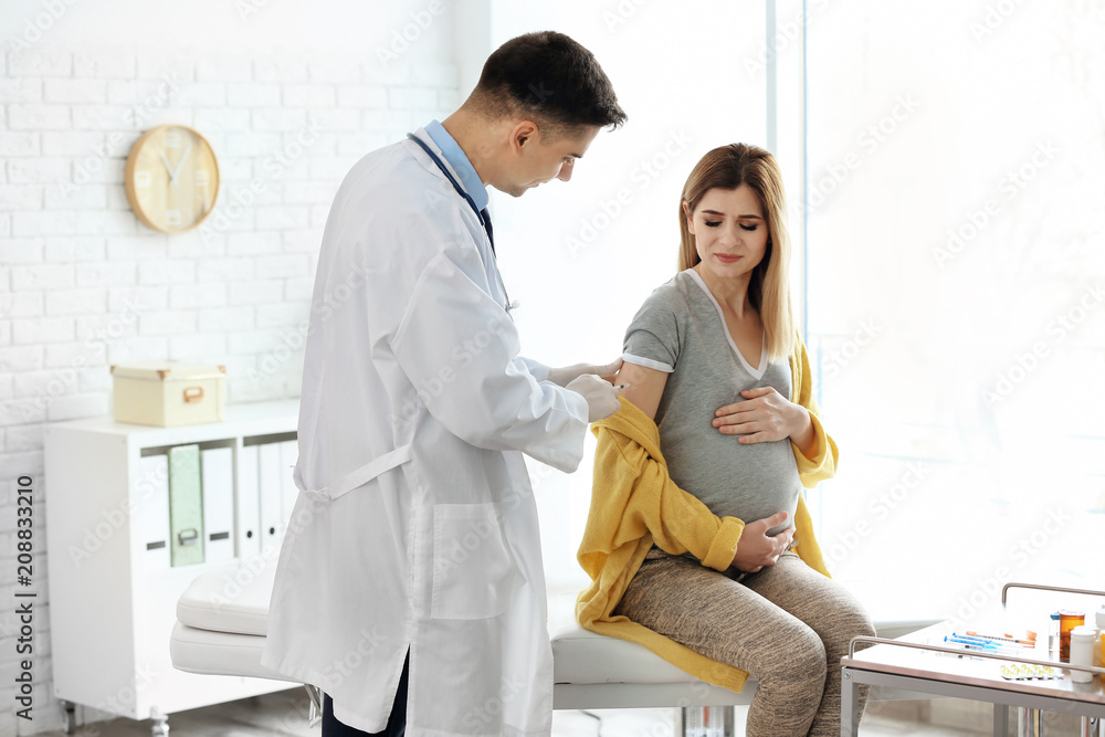 Doctor vaccinating pregnant woman in clinic Doctor vaccinating pregnant woman in clinic