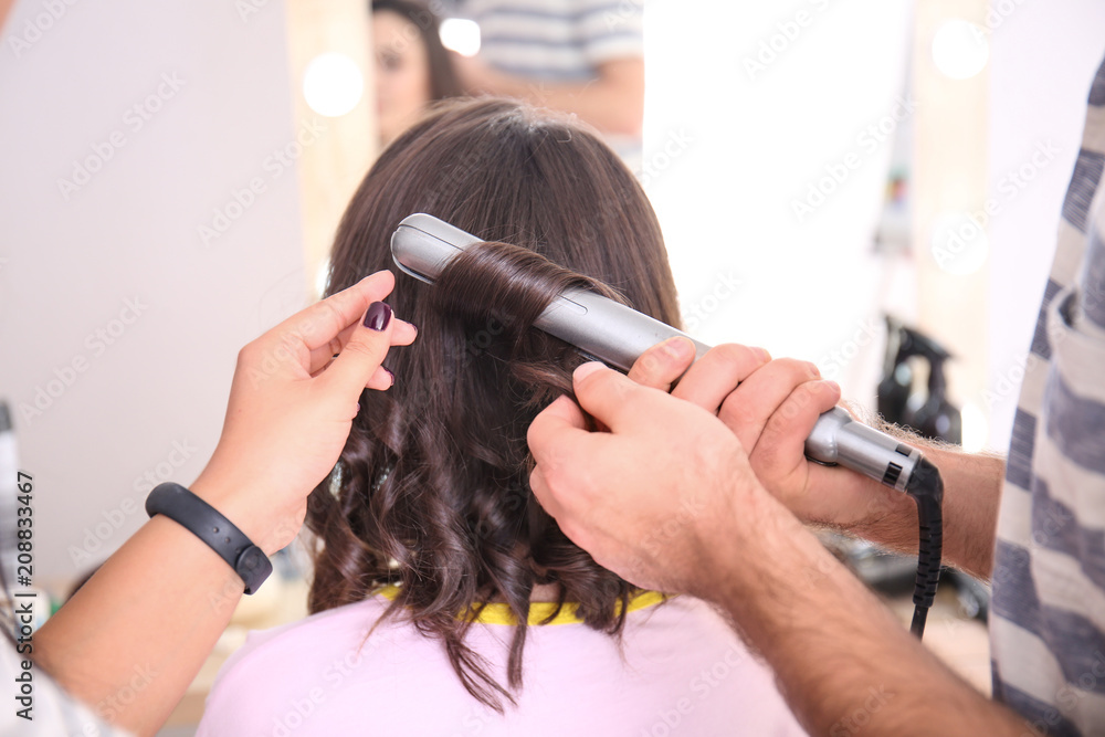 Professional hairdresser and trainee working with client in salon. Apprenticeship concept Professional hairdresser and trainee working with client in salon. Apprenticeship concept
