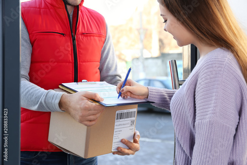 Woman signing for parcel de...