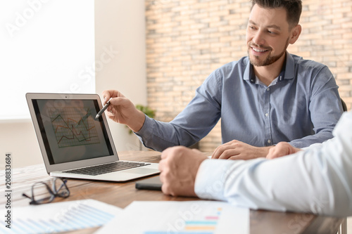 Male brokers working in off...