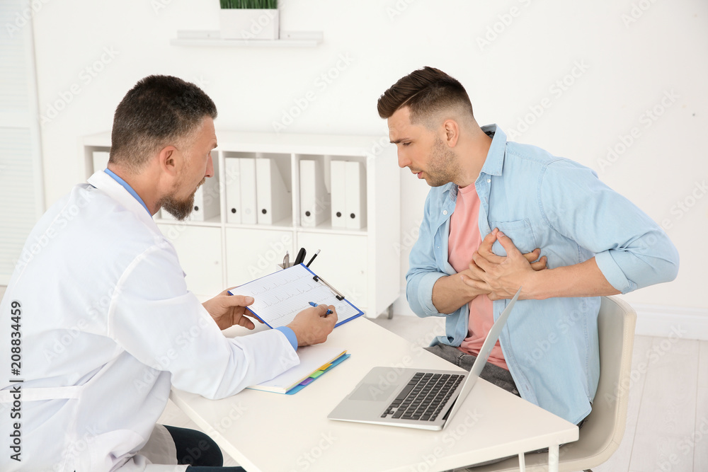 Male doctor working with patient in clinic. Cardiology consultation Male doctor working with patient in clinic. Cardiology consultation