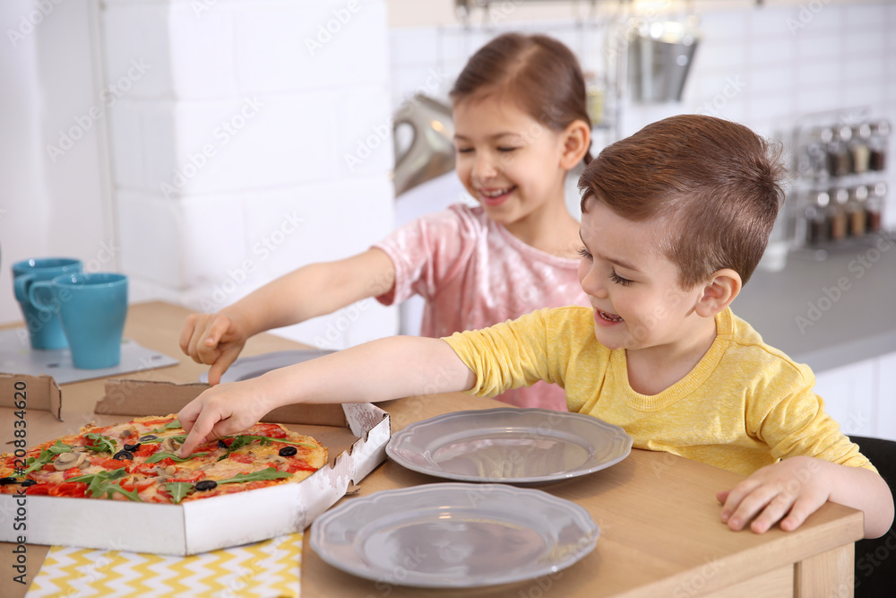 Cute little kids eating tasty pizza at home Cute little kids eating tasty pizza at home