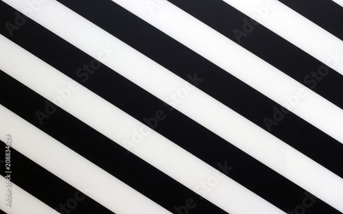 Fragment of a striped black and white piece of a plastic as a background texture