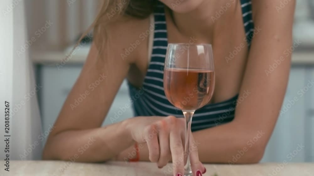 Young woman on kitchen with glass of wine, slow motion, shallow depth of field Young woman on kitchen with glass of wine, slow motion, shallow depth of field