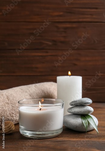 Beautiful composition with spa stones  towel and burning candles on wooden table
