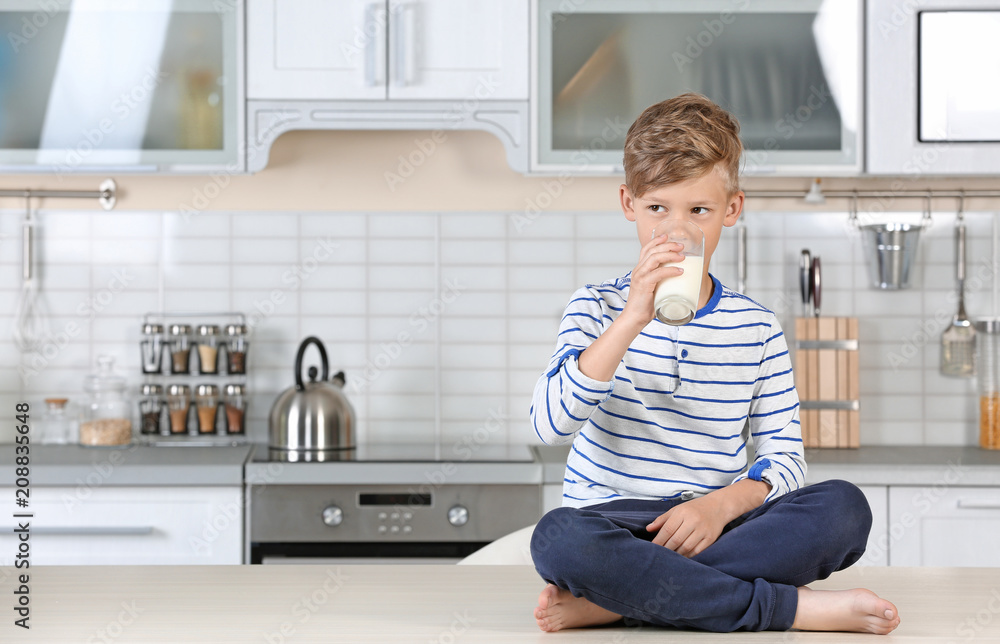 Adorable little boy with glass of milk in kitchen Adorable little boy with glass of milk in kitchen