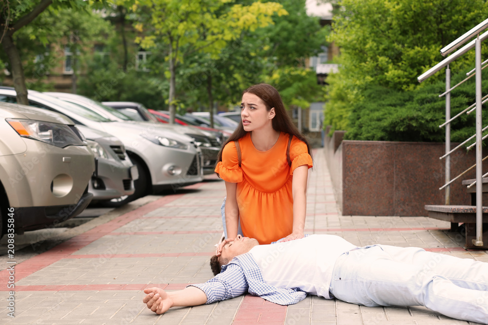 Fototapeta premium Passerby helping man with heart attack outdoors