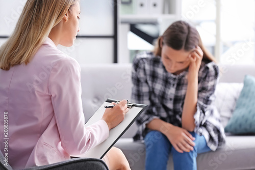 Child psychologist working with teenage girl in office