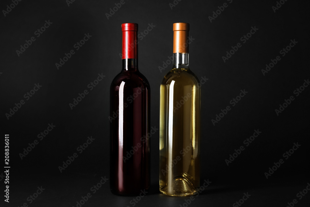 Bottles of expensive red and white wines on dark background Bottles of expensive red and white wines on dark background
