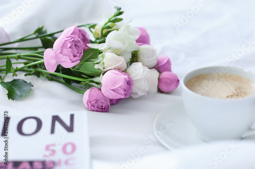 Cup of coffee, beautiful flowers and magazine on fabric