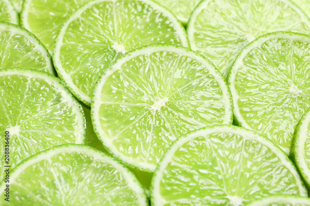 Fresh sliced ripe limes as background, closeup