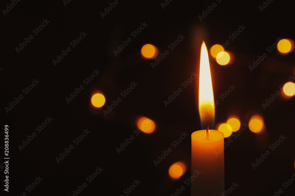 Fototapeta premium Wax candle burning on blurred background, closeup