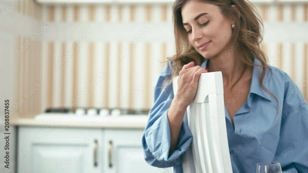 Young woman on white chair with glass of wine wearing blue shirt, slow motion, shallow depth of field Young woman on white chair with glass of wine wearing blue shirt, slow motion, shallow depth of field