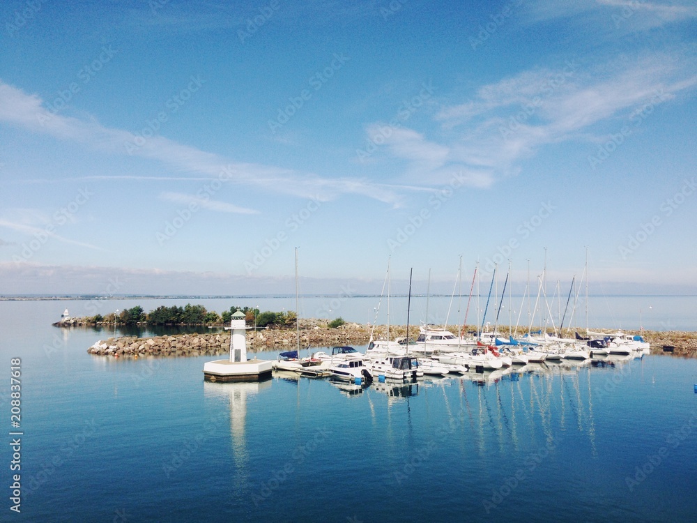 Small harbour with lighthouse and sailboats Small harbour with lighthouse and sailboats