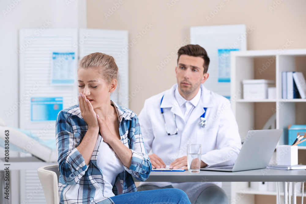 Coughing young woman visiting doctor at clinic Coughing young woman visiting doctor at clinic