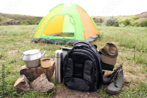 Camping gear and tourist tent in wilderness