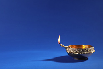 Diwali diya or clay lamp on color background
