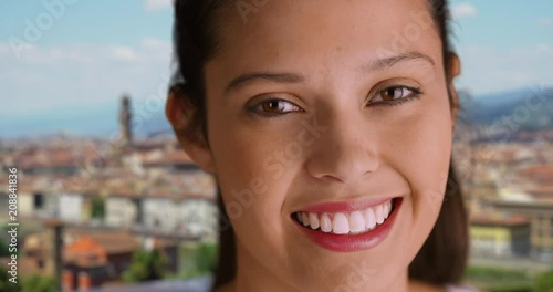 Close up of Caucasian woman in Florence smiling cheerfully at camera, Portrait of happy millennial tourist with view of Florence cityscape in background, 4k