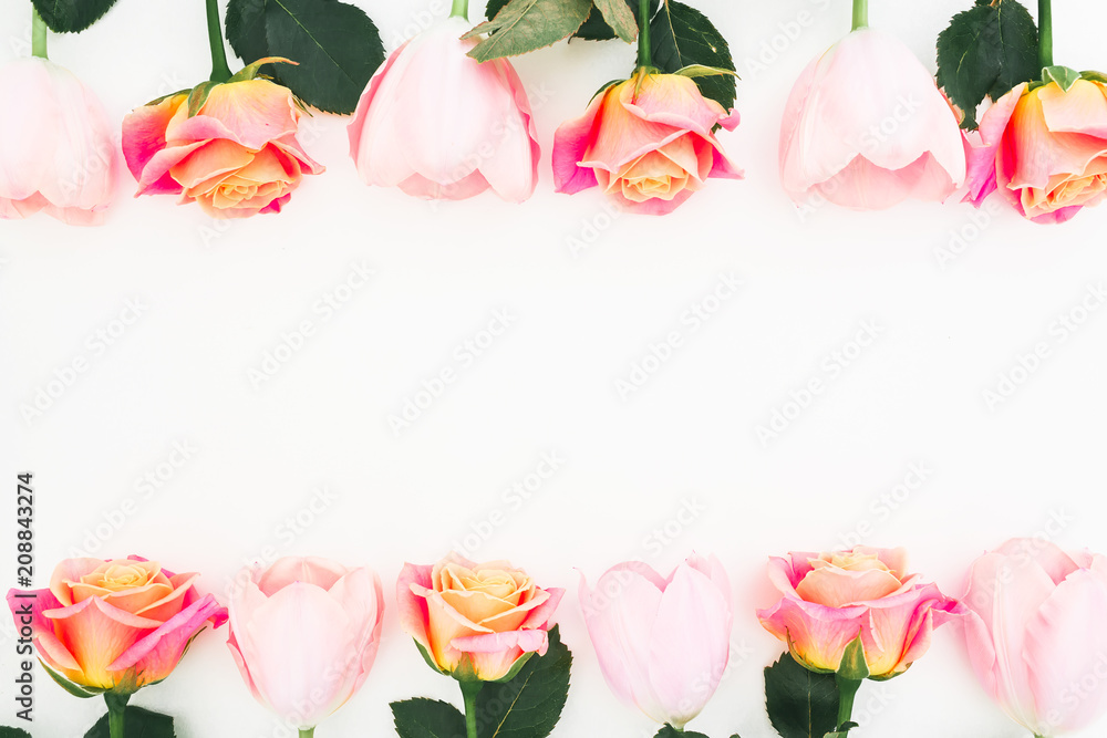 Floral frame made of roses and tulips flowers and green leaves on white background. Flat lay, top view. Flower background Floral frame made of roses and tulips flowers and green leaves on white background. Flat lay, top view. Flower background