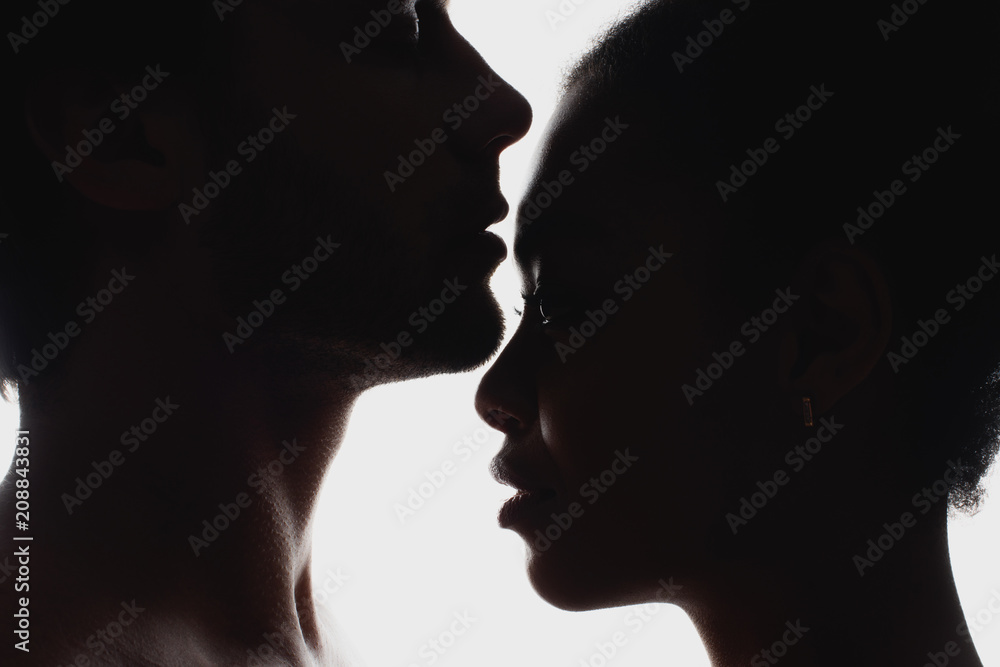 side view of silhouettes of interracial couple in love