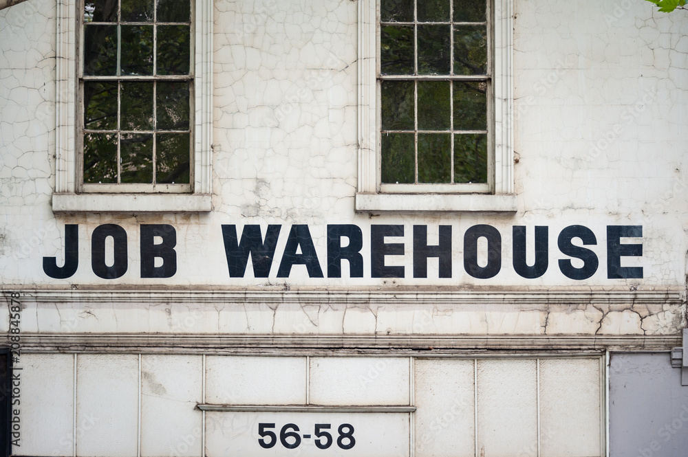 Obraz premium Job warehouse sign on white wall of an old, unused building