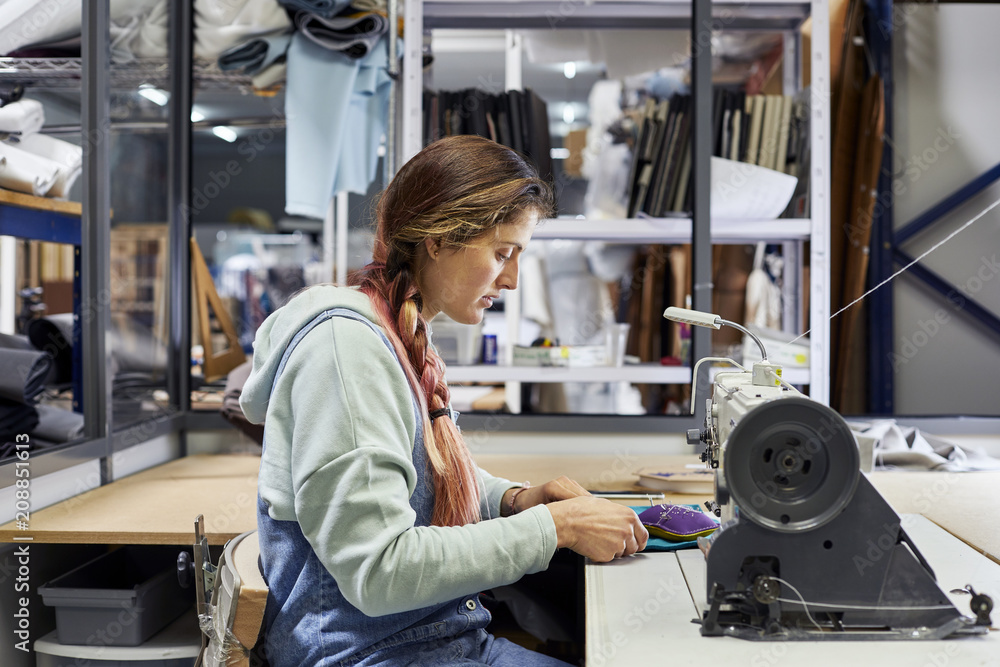 Female Worker Stitching Fabric At Workbench In Sofa Workshop Female Worker Stitching Fabric At Workbench In Sofa Workshop