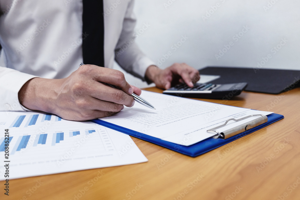 Businessman is using a pen for financial data analyzing counting Businessman is using a pen for financial data analyzing counting
