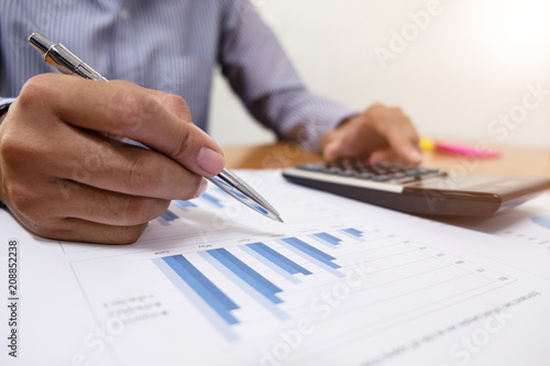 Businessman is using a pen for financial data analyzing counting